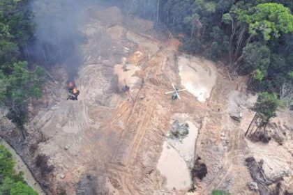 Ação de combate ao garimpo ilegal em área de floresta, com helicóptero e fogo.