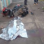 Acidente de moto com vítima fatal: moto destruída e corpo coberto.
