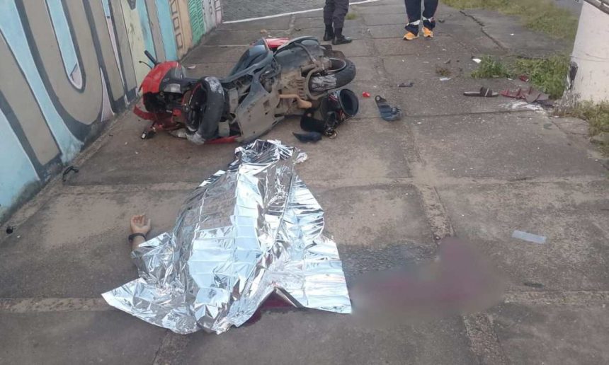 Acidente de moto com vítima fatal: moto destruída e corpo coberto.