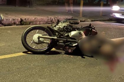 Acidente de trânsito com motocicleta na rua à noite.
