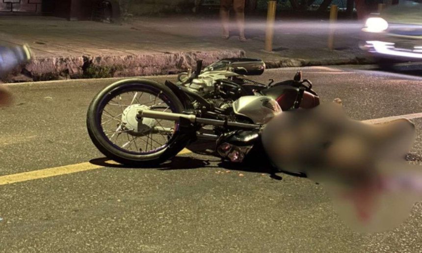Acidente de trânsito com motocicleta na rua à noite.