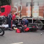 Acidente de trânsito envolvendo moto e caminhão na avenida Santos Dumont. Socorristas atendem a vítima.