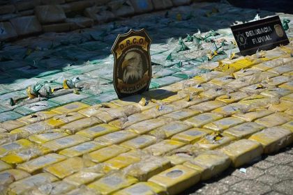 Apreensão de drogas no Rio Solimões, com policiais e entorpecentes embalados.