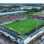 Arena da Amazônia, estádio de futebol em Manaus, com jogo em andamento.