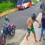 Assalto a mulher na porta de casa por motociclista. Crime registrado por câmera de segurança.