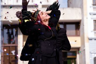 Atriz celebrando em um evento cultural, com confetes no ar.