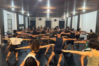 Aula de dança afro em Manaus com diversos participantes praticando movimentos.