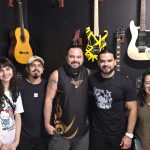Banda e equipe do Critical Age posam para foto em estúdio com guitarras.