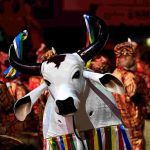 Boi-bumbá em apresentação no Sambódromo de Manaus, com adereços coloridos e público ao fundo.