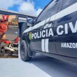 Carro da Polícia Civil do Amazonas com cena de crime ao fundo.