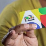 Cartão Bolsa Família em mãos, mostrando o programa de assistência social.