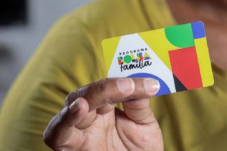 Cartão Bolsa Família em mãos, mostrando o programa de assistência social.