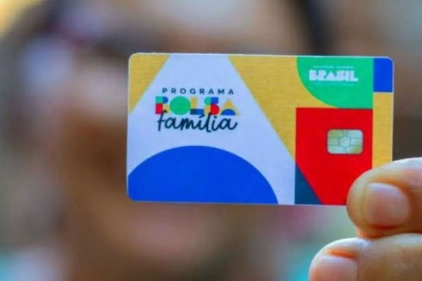 Cartão do programa Bolsa Família em mãos, com logo do programa e informações sobre benefícios.
