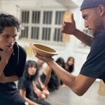 Cena do espetáculo 'A Memória da Pedra' com atores em atuação.