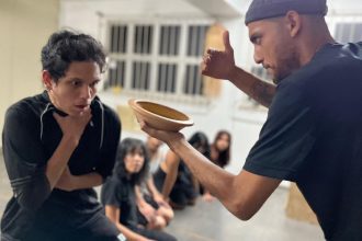 Cena do espetáculo 'A Memória da Pedra' com atores em atuação.