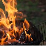 Churrasqueira com fogo intenso e grelha, após acidente com motocicleta.