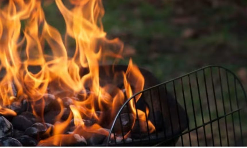 Churrasqueira com fogo intenso e grelha, após acidente com motocicleta.