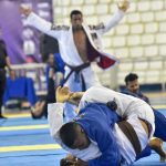 Competição de Jiu-Jitsu em Manaus: atletas lutando, árbitros e público presentes.
