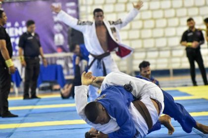 Competição de Jiu-Jitsu em Manaus: atletas lutando, árbitros e público presentes.