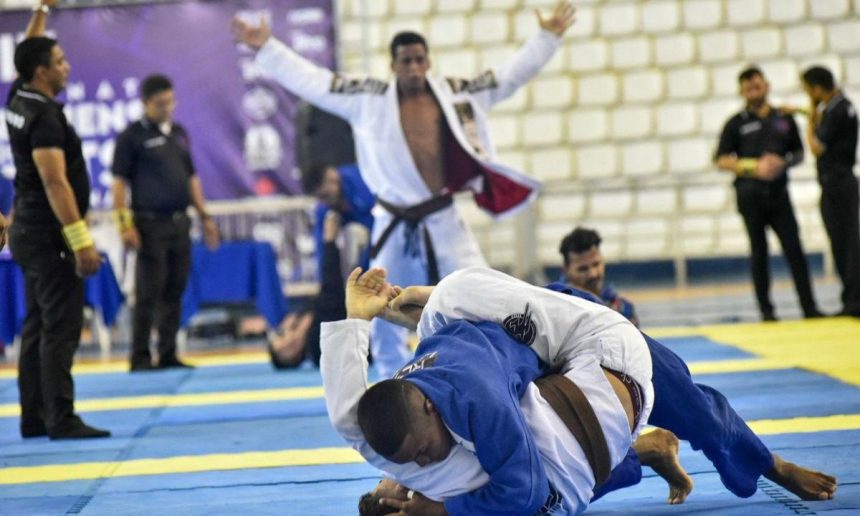 Competição de Jiu-Jitsu em Manaus: atletas lutando, árbitros e público presentes.