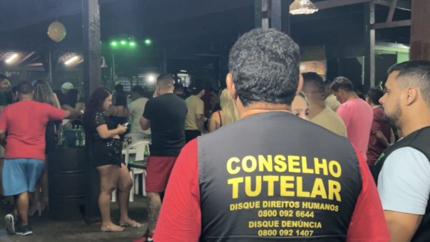 Conselheiro Tutelar em ação em ambiente noturno, lugares conhecidos como adegas, com pessoas ao fundo. Discagem para direitos humanos e denúncia.