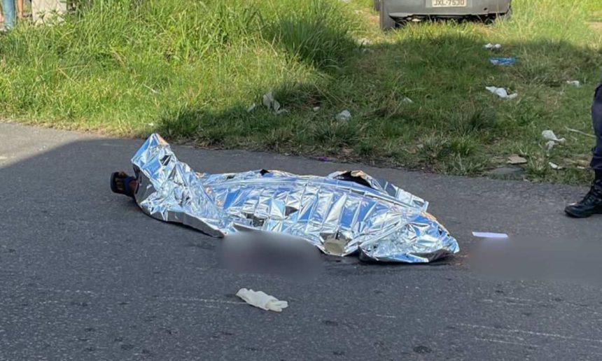Corpo coberto em estrada após homicídio.