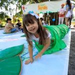 Criança sorrindo em festival de férias, dentro de túnel verde