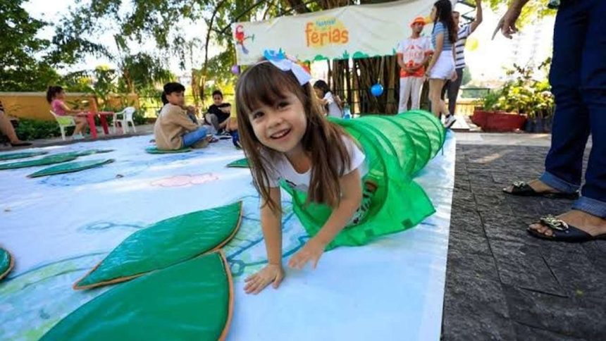 Criança sorrindo em festival de férias, dentro de túnel verde