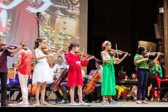 Crianças do Centro Suzuki se apresentam em recital no Palácio da Justiça, tocando violino.