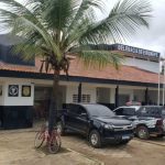 Delegacia de Eirunepé com viaturas e árvore.