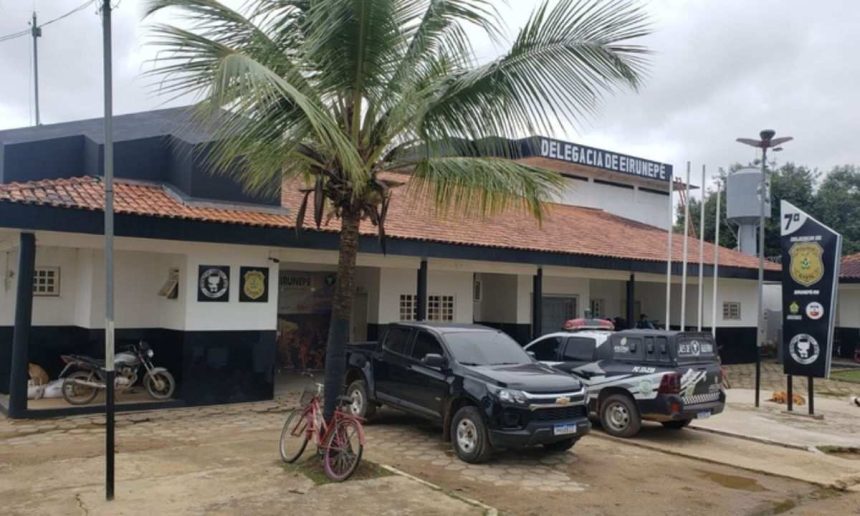 Delegacia de Eirunepé com viaturas e árvore.