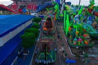 Desfile de carnaval com carros alegóricos vibrantes e multidão em evento.