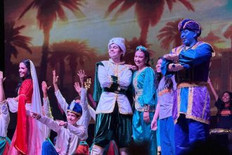 Elenco de 'Aladin' da Nova Igreja Batista em apresentação teatral.