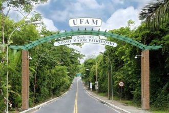 Entrada da Universidade Federal do Amazonas (UFAM) com arco verde e estrada