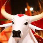 Escultura de boi branco com chifres e detalhe em coração vermelho na testa, em evento do Boi Garantido.