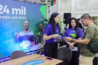 Evento de lançamento de programa habitacional Feirão Amazonas Meu Lar em Manaus, Amazonas. Pessoas interagem em um estande.
