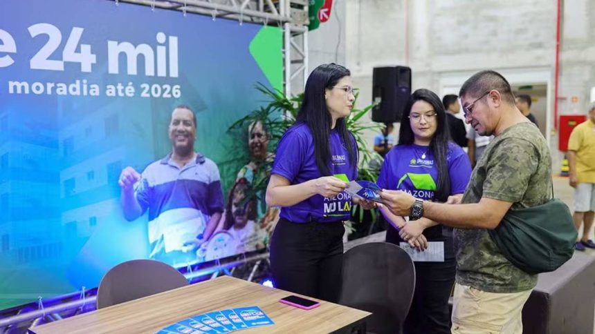 Evento de lançamento de programa habitacional Feirão Amazonas Meu Lar em Manaus, Amazonas. Pessoas interagem em um estande.