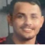 Fabrício, 24 anos, vítima de assassinato, com camisa preta e detalhe vermelho.