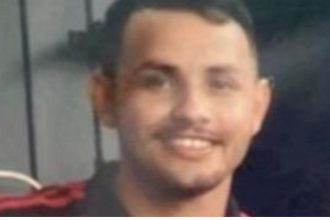 Fabrício, 24 anos, vítima de assassinato, com camisa preta e detalhe vermelho.