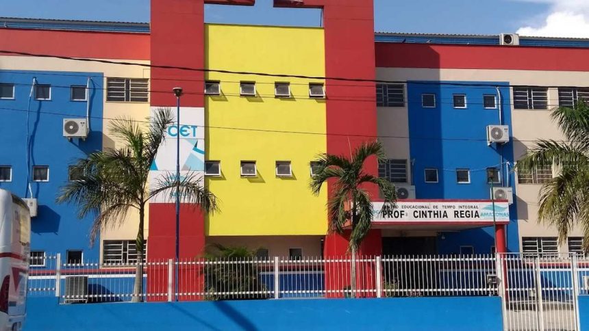 Fachada colorida de escola em Manaus, com letreiro da EJA e árvores.