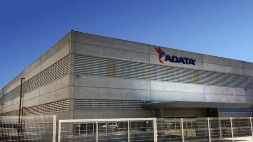Fachada da ADATA com logo, céu azul e cerca.