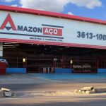 Fachada da Amazon Aço em Manaus, com letreiro e informações de contato.