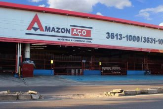 Fachada da Amazon Aço em Manaus, com letreiro e informações de contato.