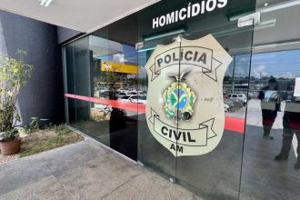 Fachada da Delegacia de Homicídios com símbolo da Polícia Civil do Amazonas.