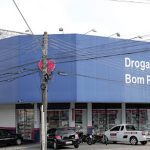 Fachada da Drogarias Bom Preço em Manaus, com letreiro e carros estacionados.