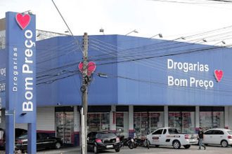 Fachada da Drogarias Bom Preço em Manaus, com letreiro e carros estacionados.