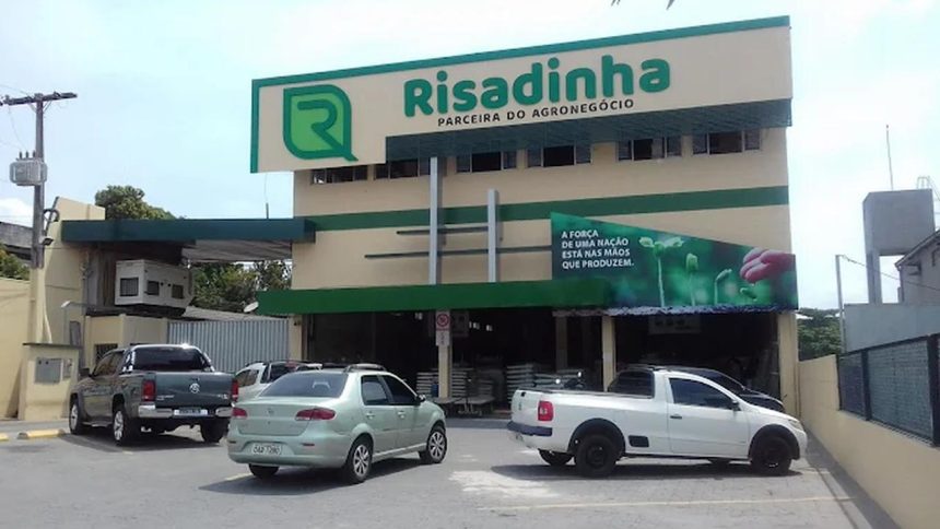 Fachada da loja Risadinha com carros estacionados. Emblema da empresa em destaque.