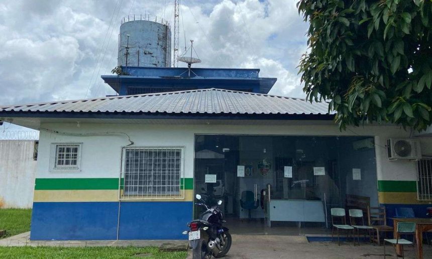 Fachada de delegacia de polícia com antena e moto estacionada
