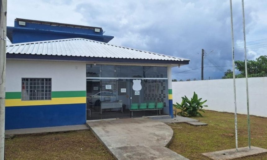Fachada de delegacia de polícia sob céu nublado.