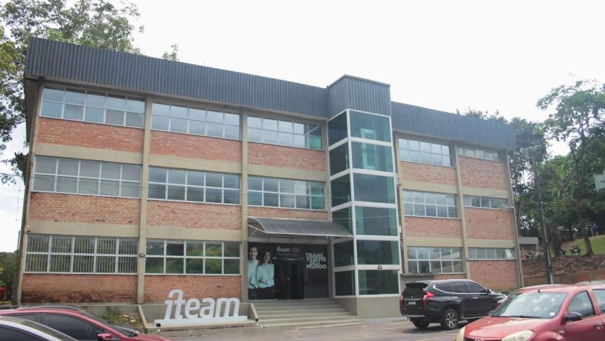 Fachada do edifício da iTeam, em Manaus, com arquitetura moderna, janelas amplas e um elevador envidraçado.